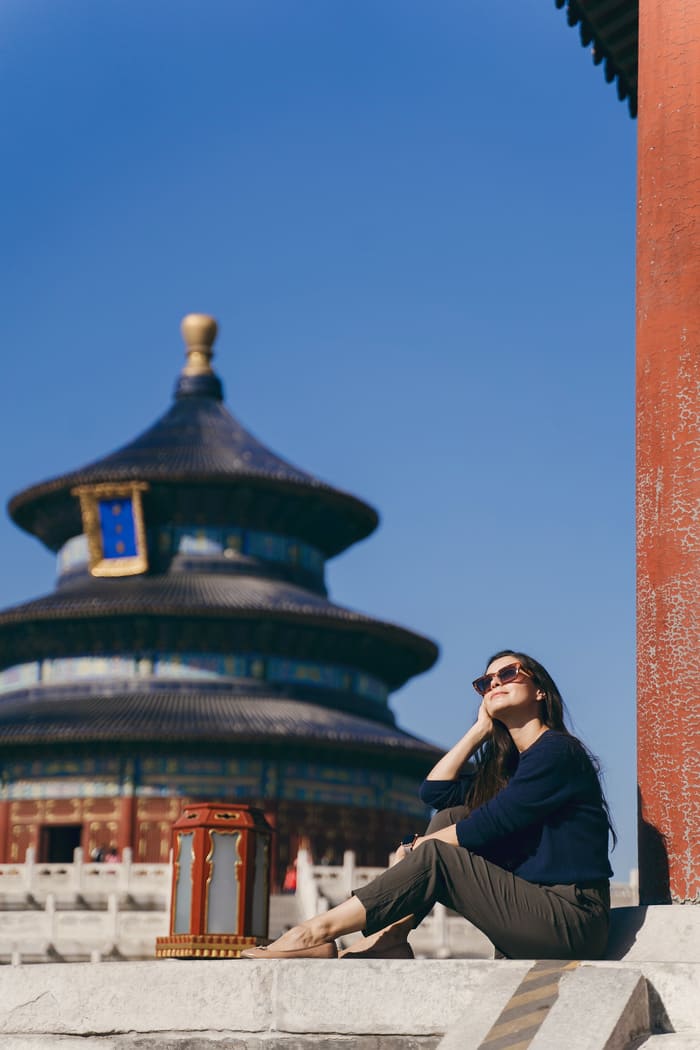 Turista sentada con Templo de fondo en bijing