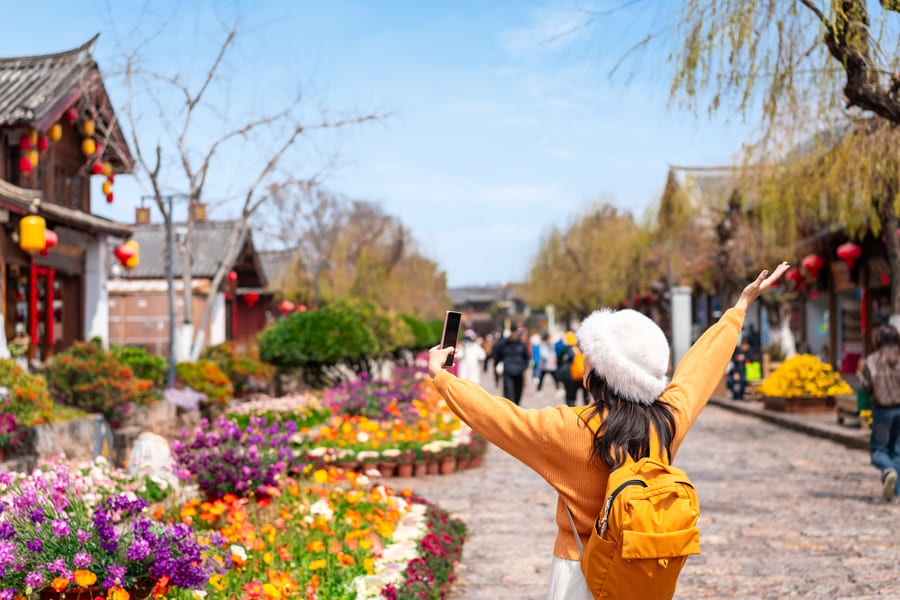 Turista con los brazos arriba adamirando los jardines chinos